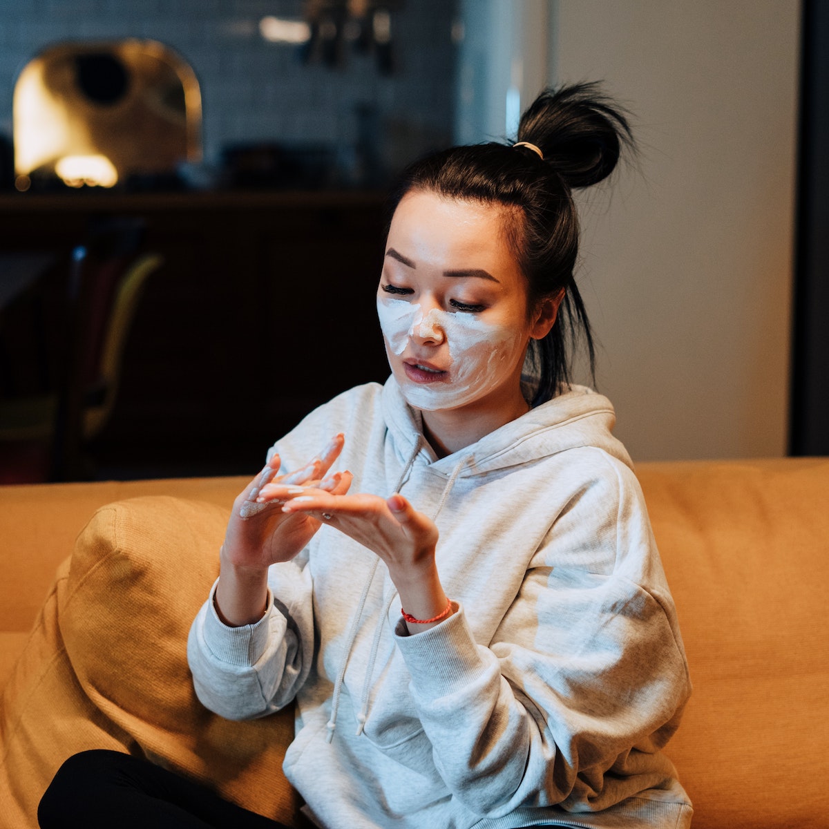 Woman tries skincare product on her sofa